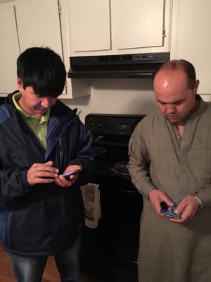 Ali, an Afghan who was co-sponsored and resettled by First Presbyterian Church in January 2015, exchanges contact information with Amanuddin, the father of an Afghan refugee family who was co-sponsored and resettled by First Presbyterian Church in January 2016. 