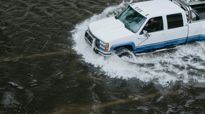 A truck barrels through high flood waters