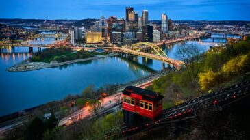 A photo of downtown Pittsburgh with the red incline car in the foreground