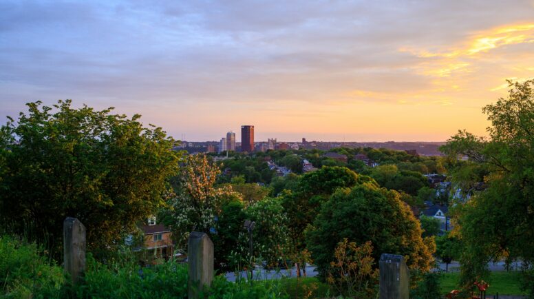 Pittsburgh sits in the distance. The sky is orange -- either sunset or sunrise.
