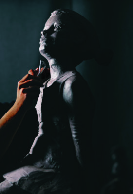 Man sculptor creates sculpt bust clay human woman sculpture. Statue craft creation workshop.