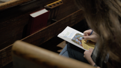 A person writing a prayer square.