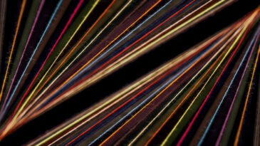 Converging Multi-colored Sewing Thread on a black background