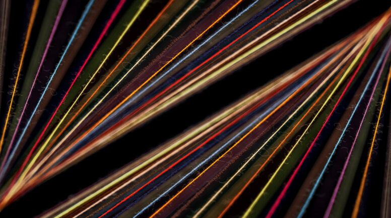 Converging Multi-colored Sewing Thread on a black background