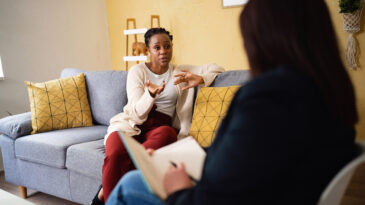 Woman of Black ethnicity, sharing her thoughts and emotion at the therapy, led by the female psychotherapist