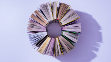 top view of stack of books in circle on violet tabletop. Lent devotional feature image.