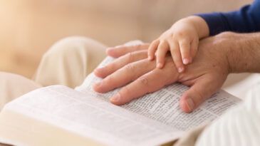 Grandad reading stories from the Holy Bible to his young grandson