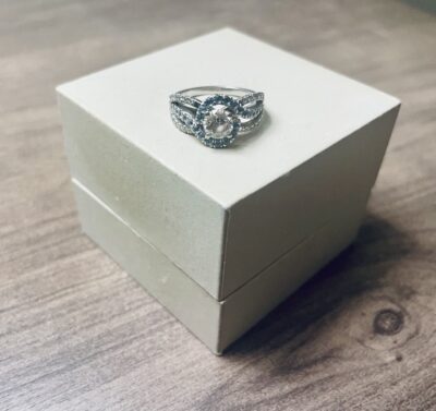 Katy's redesigned ring. Small blue and clear stones swirl around a central diamond.