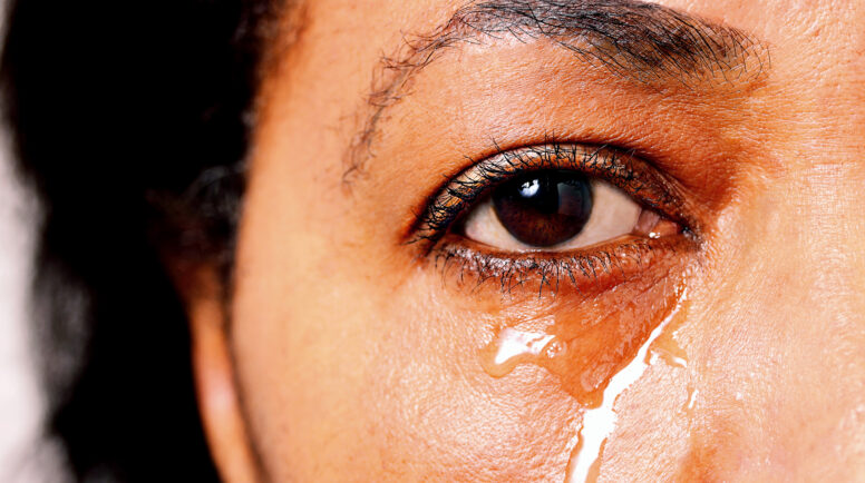 Sad African American female with tears rolling down her face