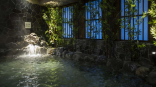 A large, indoor bath with a waterfall