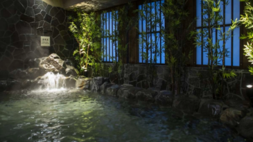 A large, indoor bath with a waterfall