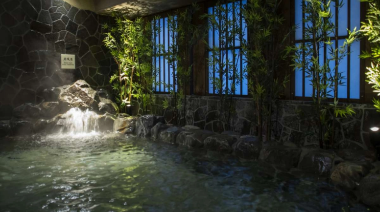 A large, indoor bath with a waterfall