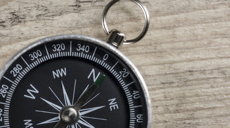 Close up of a vintage compass on wood