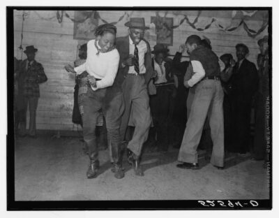 A black men dancing the jitterbug in a black and white photo.