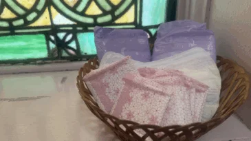 A basket of pads sits on a window seal with stained glass in the background