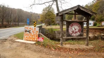 At the entrance to Camp Grier, there is a spray painted sign that reads, "Meals 4-7, shower, laundry"