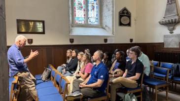 A group of Presbyterian College students sit and listen to a speaker.