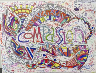 A large coloring design with the word "compassion."