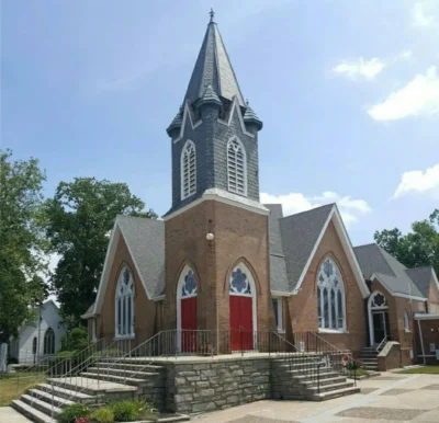 A brick church with a steeple and a red door. This is the Presbyterian Church at Hammonton.