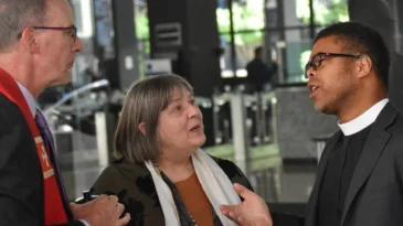 Three Chicago ministers talk during a protest.