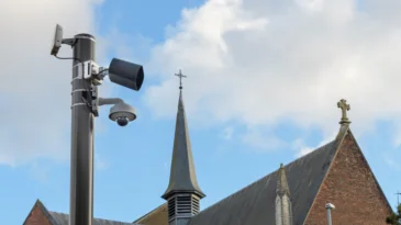 CCTV Security Camera or surveillance operating on a city street against the background of a church