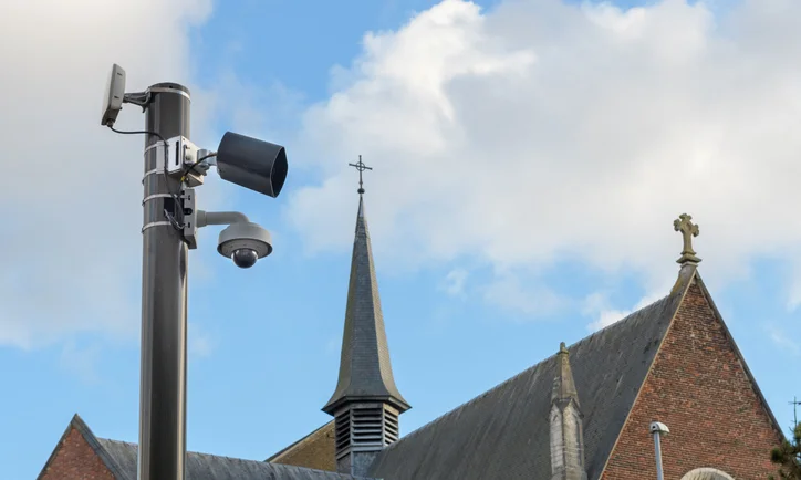CCTV Security Camera or surveillance operating on a city street against the background of a church