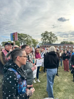 Two pastors stand in a crowd of protestors. They're holding holy oil.