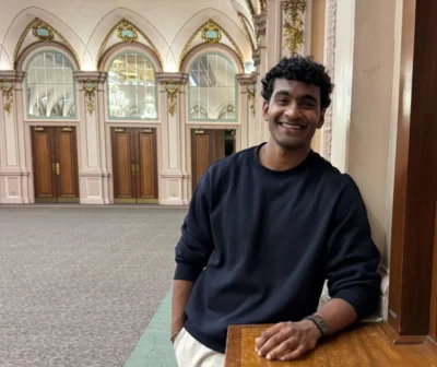 A young man smiles at the camera.
