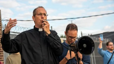 Father Brendan Curran rallies protesters outside the Broadview ICE facility in Broadview, Ill.