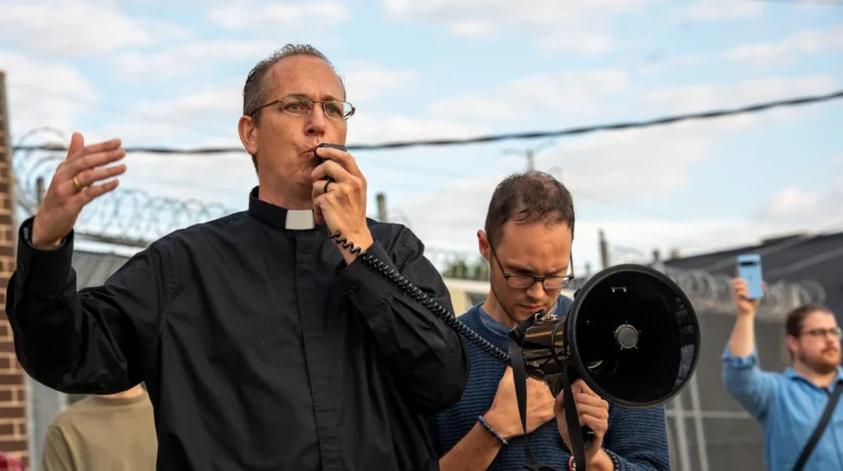Father Brendan Curran rallies protesters outside the Broadview ICE facility in Broadview, Ill.