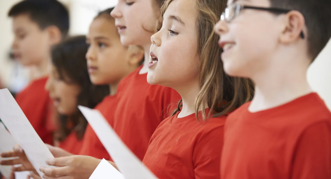 Group Of School Children Singing In Choir Together