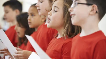 Group Of School Children Singing In Choir Together