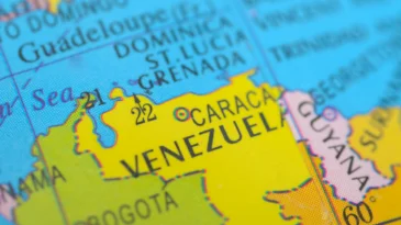 A vibrant political map highlights Venezuela in bright yellow, clearly marking its capital, Caracas, and its strategic position on the Caribbean coast of South America. stock photo