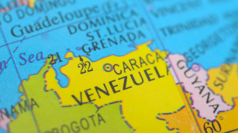 A vibrant political map highlights Venezuela in bright yellow, clearly marking its capital, Caracas, and its strategic position on the Caribbean coast of South America. stock photo