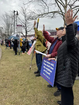 A group with signs stands outside