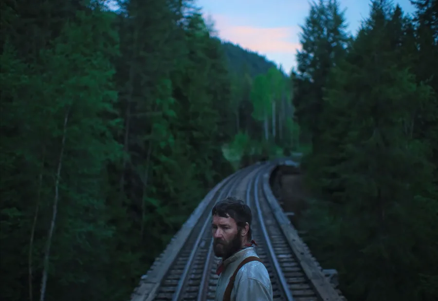 A man stands on train tracks.