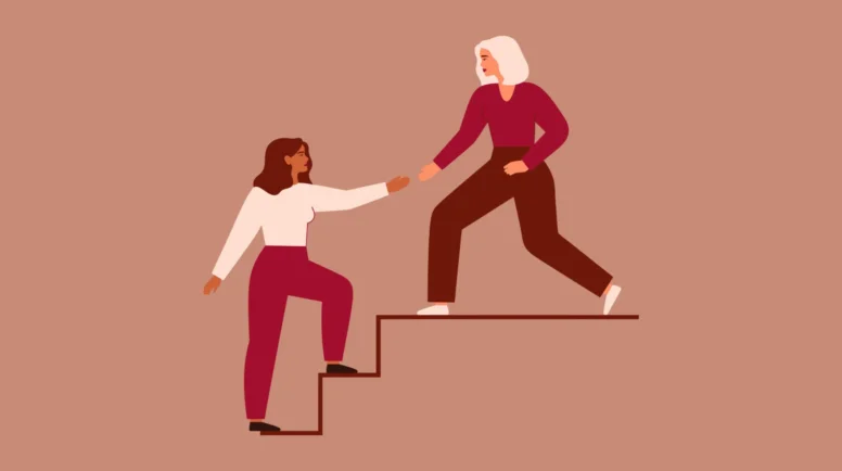 a woman walking up stairs. another woman lending a hair.