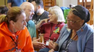 A group of women in conversation, two women in the foreground