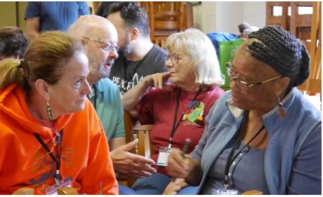 A group of women in conversation, two women in the foreground