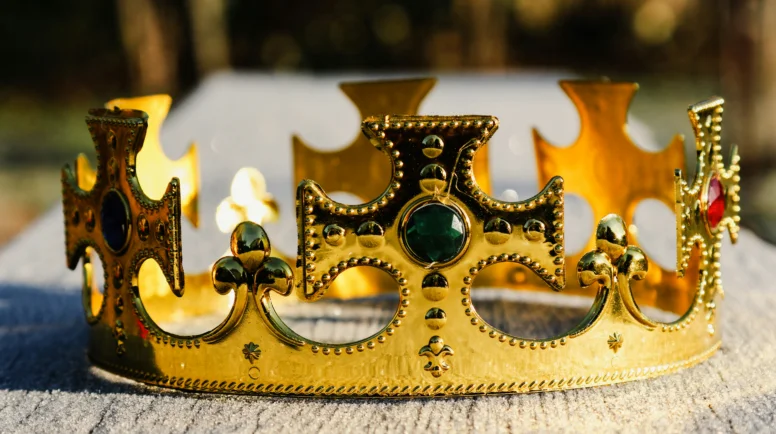 a gold crown on a wooden bench