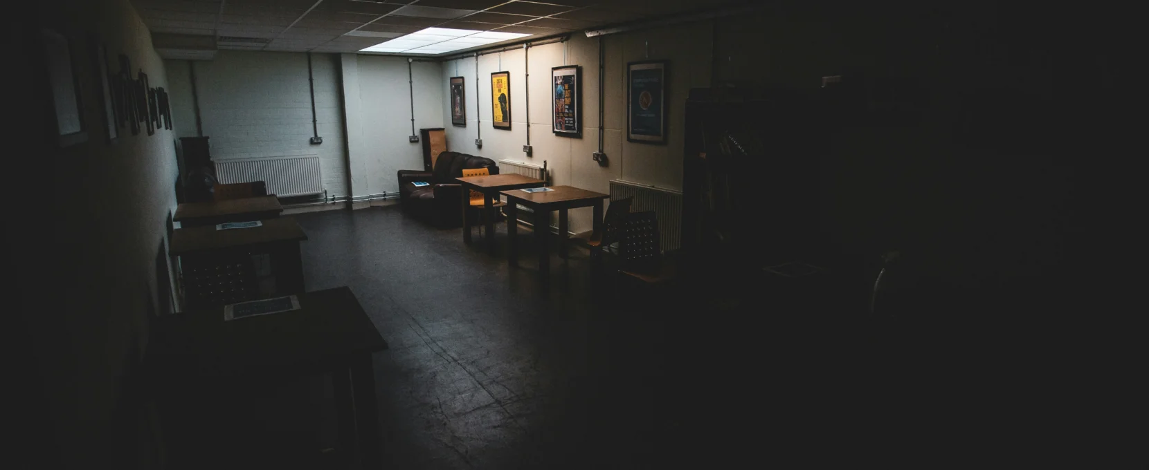 A dark office floor with a couple of desks