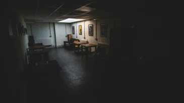 A dark office floor with a couple of desks
