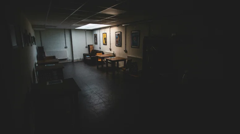 A dark office floor with a couple of desks