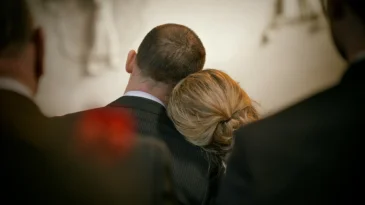 A woman leans her head on a man's shoulder