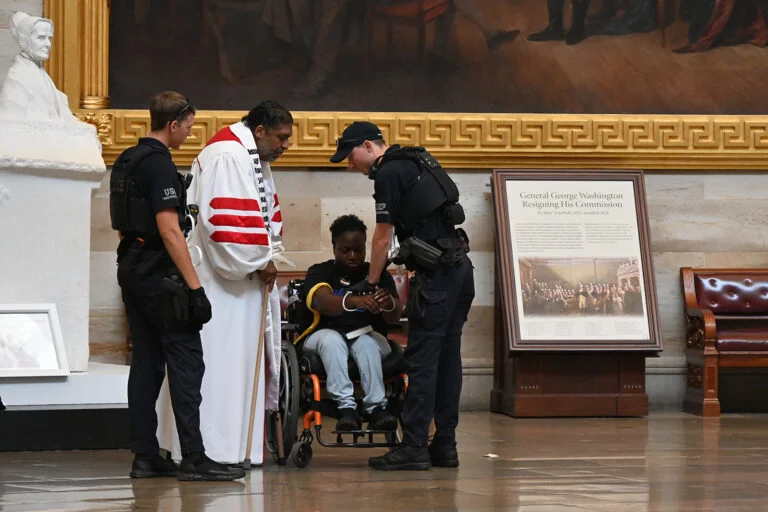 Police arrest the Rev. William Barber II and Suvya Carroll in the U.S. Capitol Rotunda,