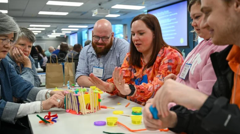 A group of people play at Louisville Center a game around a table
