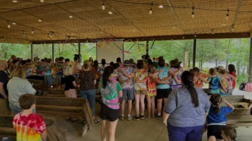 A group of young campers gather to sing