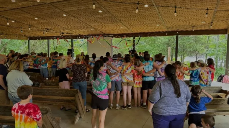 A group of young campers gather to sing