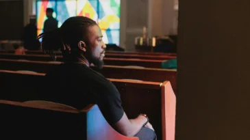 man sits in a pew