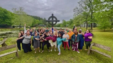 A group of people smile at More Light Presbyterians retreat at Ferncliff